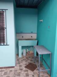 Outdoor laundry space with turquoise walls utility sink and tiled floors in Vacamonte Panama