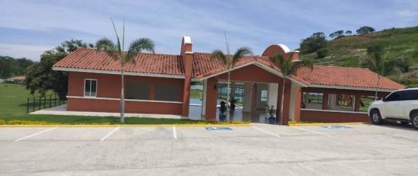 Community clubhouse with terracotta roof and palm trees in Chame PH near beaches