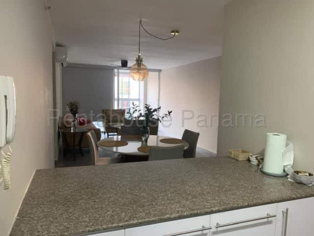 Outdoor pool with sun deck surrounded by green trees PH Altos del Golf Panama City