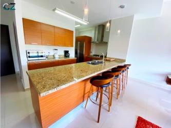 Kitchen featuring granite counters and wood cabinetry in PH Soleo Panama Pacifico