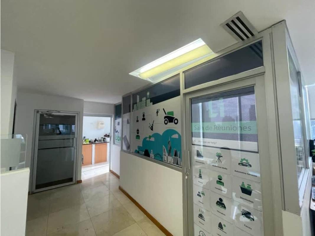 Partitioned workspaces with glass walls inside office at El Tornillo