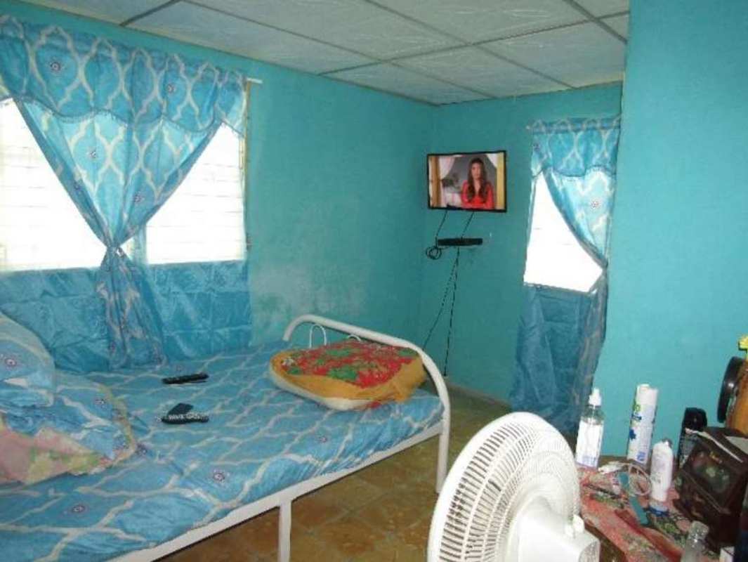Basic bedroom with tiled floor and window bars in Samaria Sector 3 affordable housing Panama