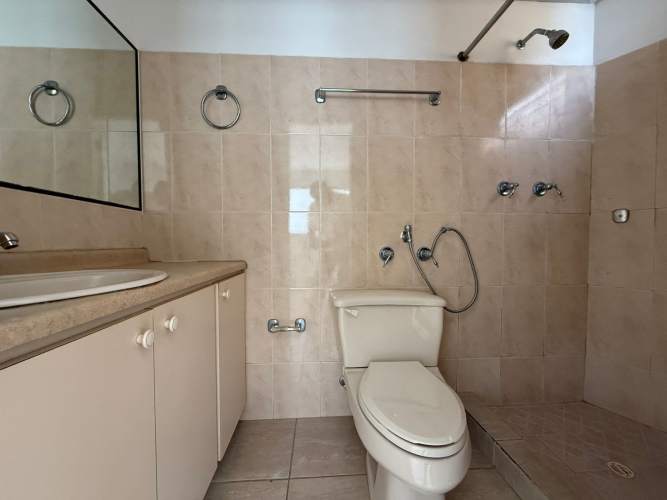 Bathroom with shower, vanity, and beige tiles in PH Parque Lefevre Panama