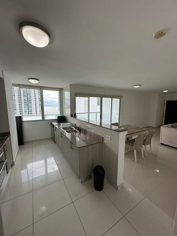 Dining space next to large windows with panoramic city and ocean view PH Moon Tower Panama