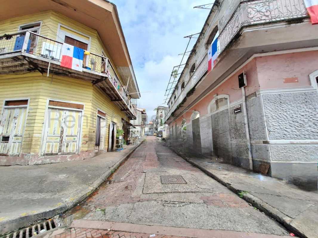 Older two-story residential building with balconies near vacant land Casco Viejo Panama