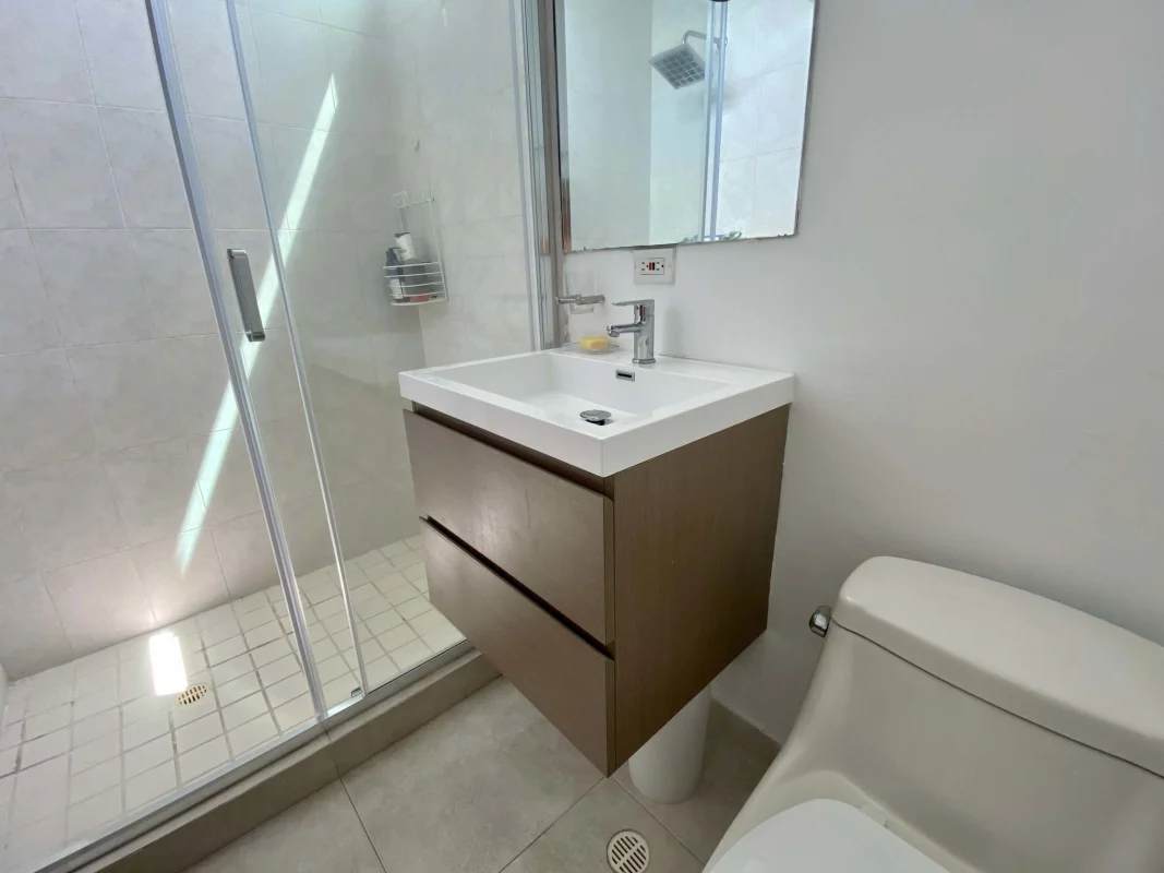 Modern bathroom with glass enclosed shower, floating vanity and mirror in PH Terrawind San Francisco Panama