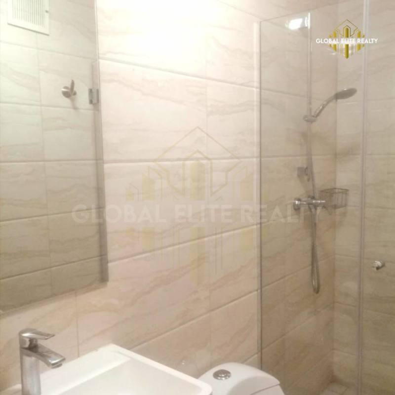Bathroom with beige tiles glass shower and modern vanity in PH Vía España Panama