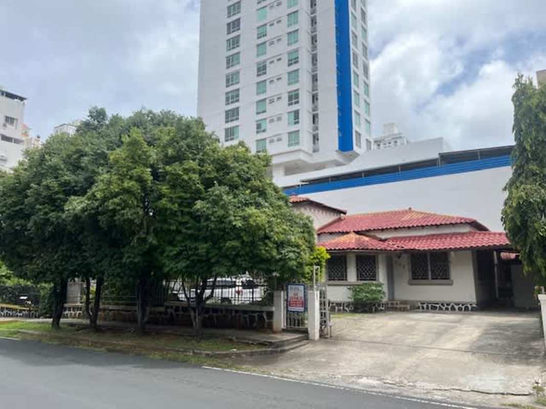 Traditional single-story house with red tile roof, gated driveway, front yard urban Panama