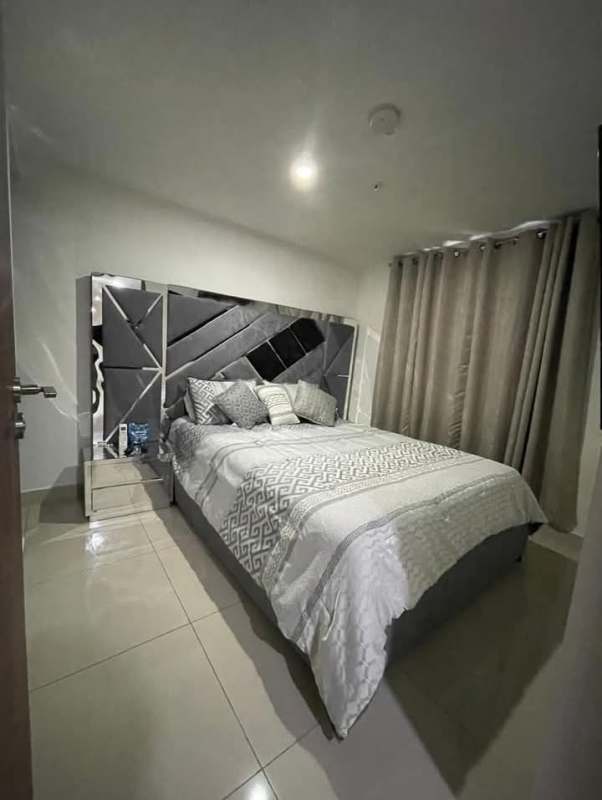 Bedroom with mirrored headboard, walk-in closet, tiled floor and smart TV in PH Worldwide Panama