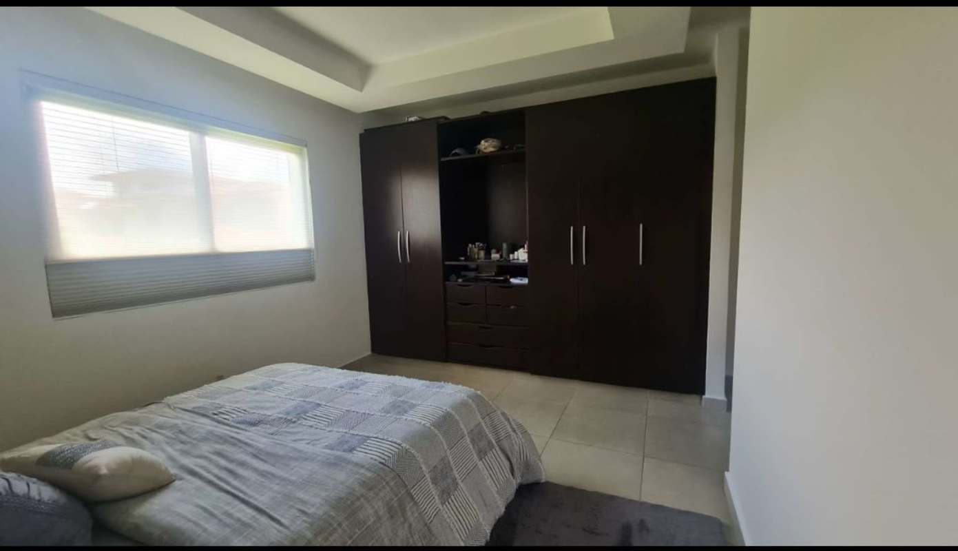 Minimalist bedroom with dark wood wardrobe in luxury Embassy Club Clayton house Panama