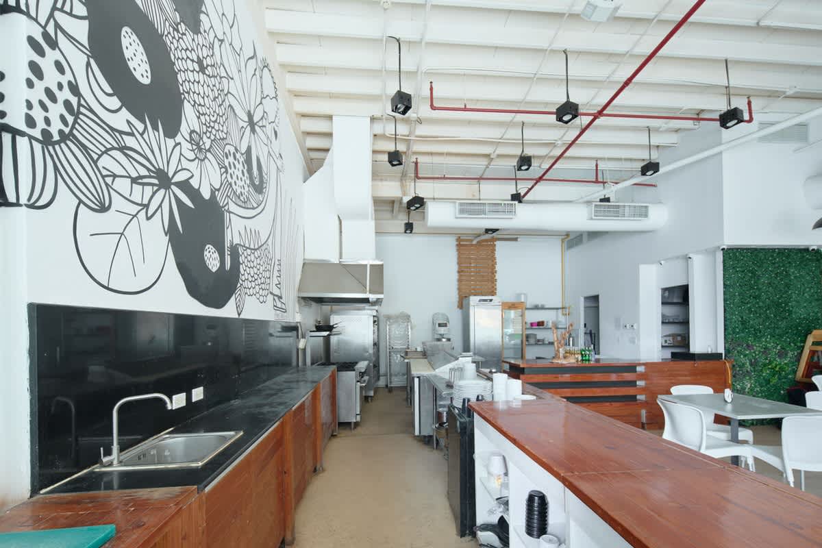 Interior restaurant setup with bar, white chairs, and greenery on Avenida Balboa Panama City
