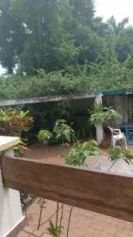 Cozy bohemian living room with red sofa, exposed beams overlooking garden Panama