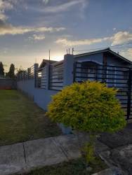 Concrete wall black metal fencing landscaped front yard and secure gate at house Quinta del Pacifico La Chorrera Panama