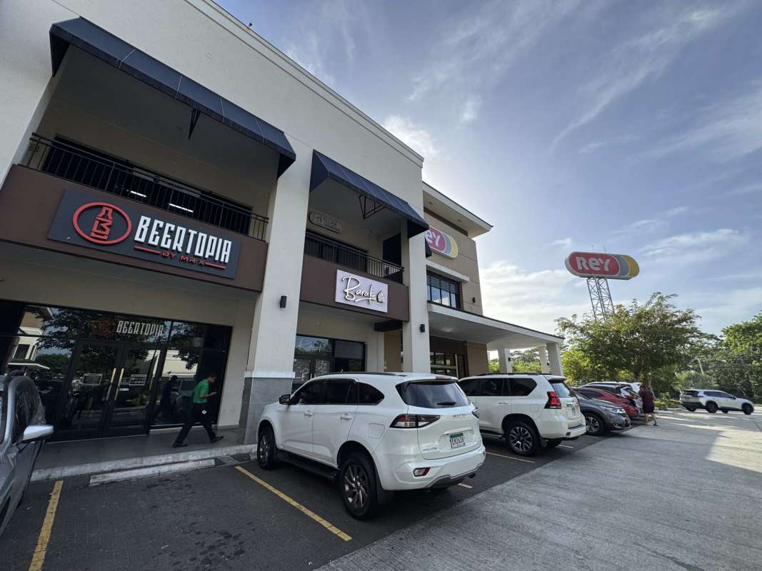Urban two-story retail shopping center with storefront signage parking lot Brisas del Golf Panama