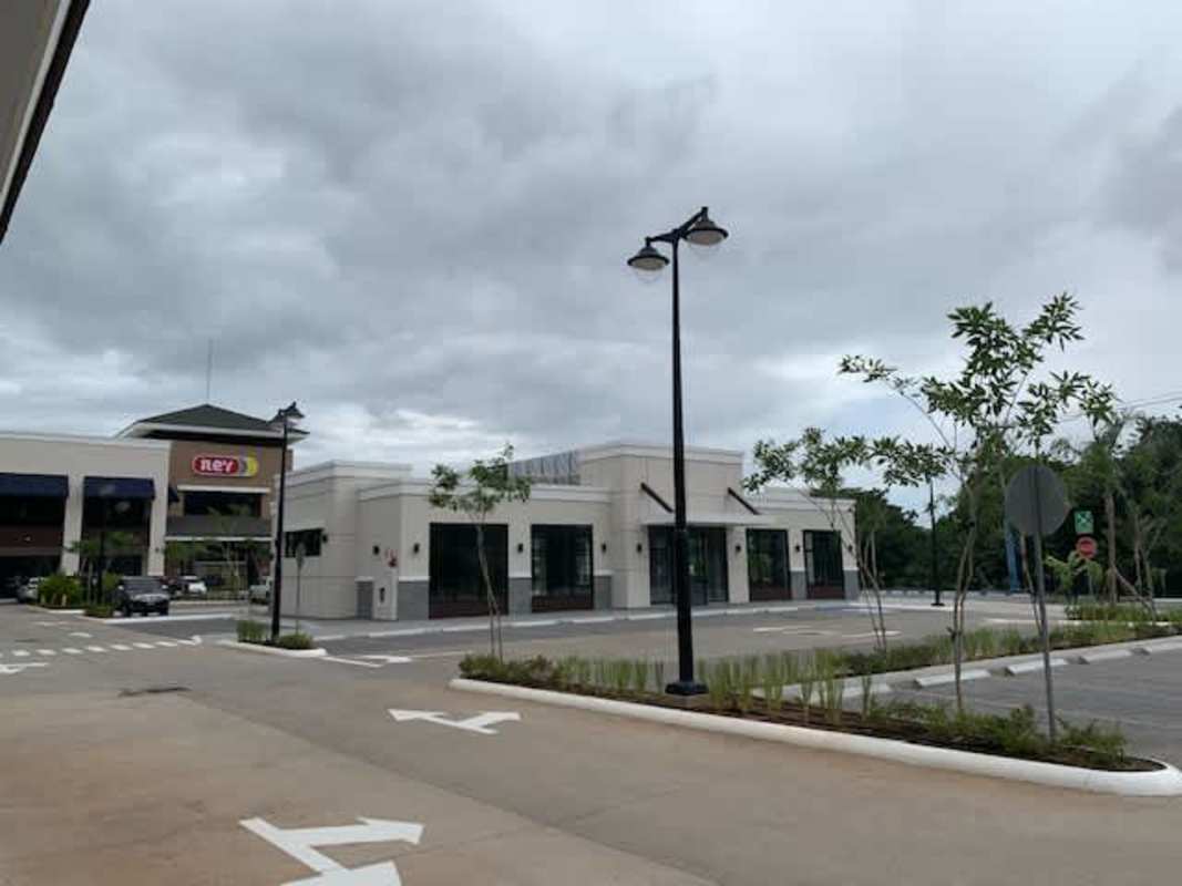 Modern commercial shopping center plaza with ample parking landscaping storefronts at Brisas del Golf Panama City