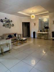 Modern dining room with blue chairs white table tile flooring in house for rent in Chitré Panama