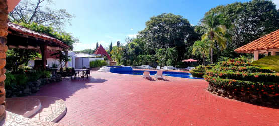 Mediterranean tropical villa exterior with lush garden, swimming pool, and spacious terraces Playa Gorgona