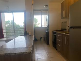Modern apartment kitchen with granite countertops and wood cabinets PH Terrazas del Oeste in Panama Oeste