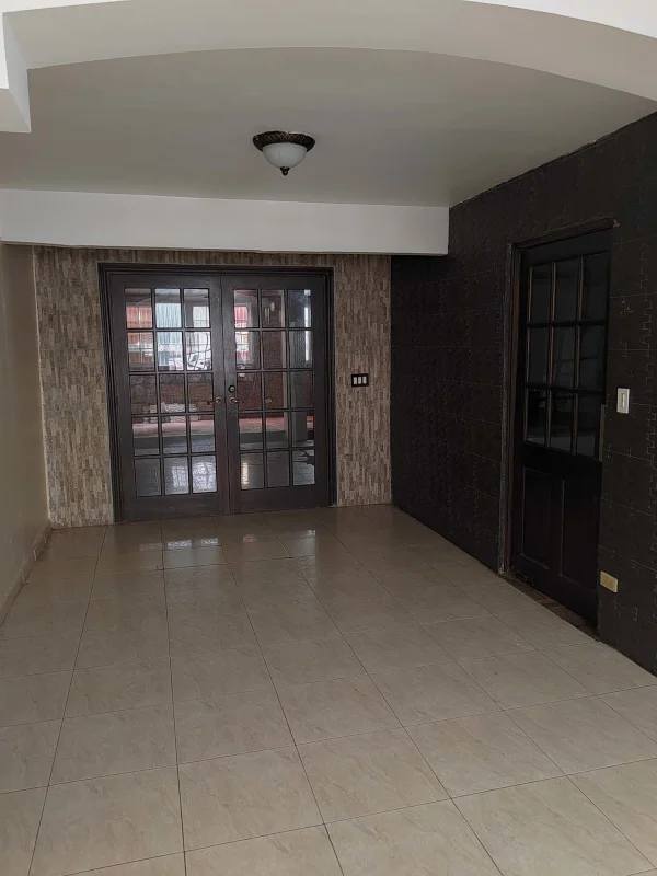 Empty bedroom with floral accent wall ceiling fan and tile floor in Cerro Viento rental home Panama