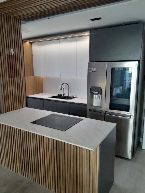 Contemporary kitchen with marble island, induction cooktop, and stainless refrigerator Panama