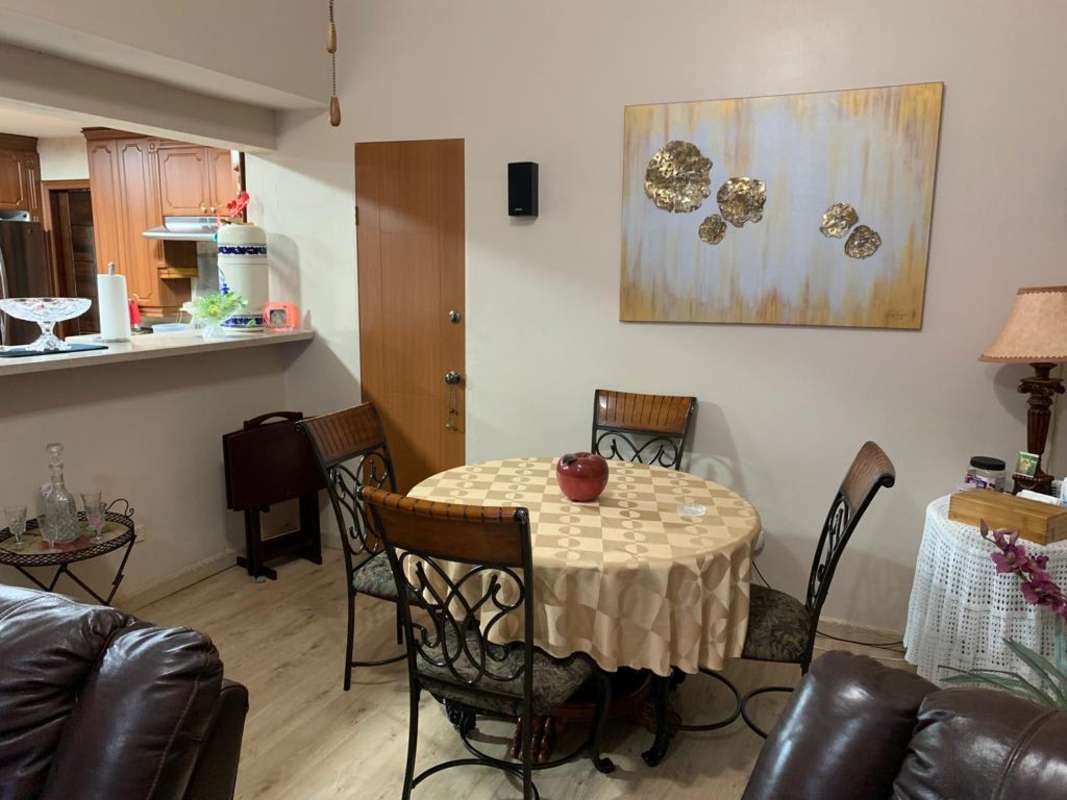 Bright dining area with round table and open kitchen PH Las Guanábanas Clayton Panama
