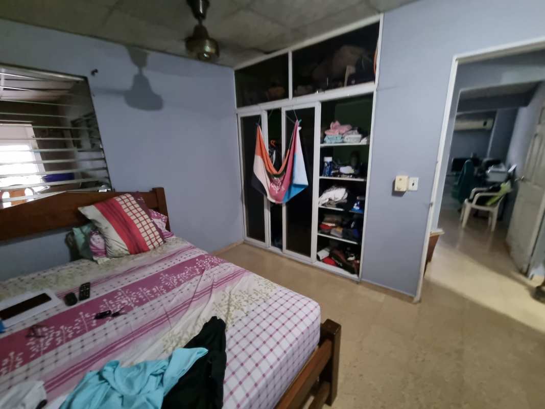 Bedroom with built-in wardrobe and ceiling fan in Don Bosco house, San Miguelito
