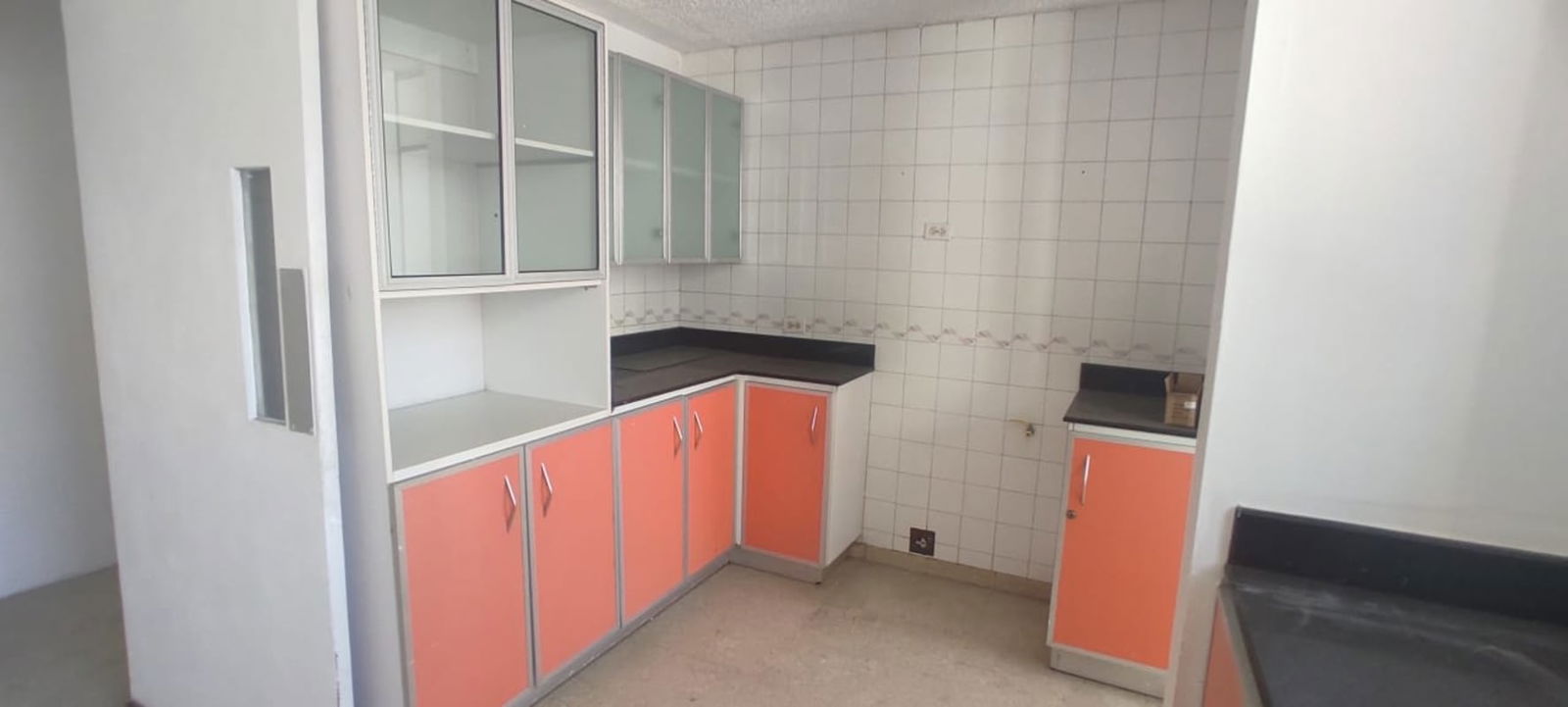 Functional kitchen with granite counters, orange cabinets, window PH Monaco Panama