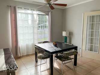 One-level ranch style house with tiled roof, metal fence, mature trees Villa María David