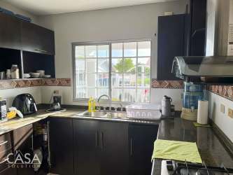 Spacious living and dining area with sectional sofa, dining table, ceiling fan in Villa María David Panama