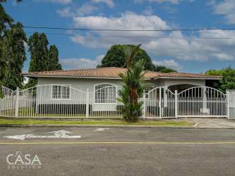Contemporary kitchen with granite countertops, dark cabinetry, large window, appliances in Villa María David Chiriquí