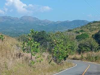 Curving rural road through grassy countryside hills in El Guzman Coclé Panama
