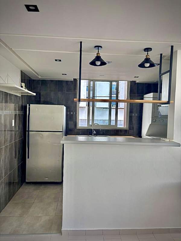 Modern open kitchen with stainless appliances, breakfast bar, and tile backsplash in Villa de las Fuentes Tower Panama City