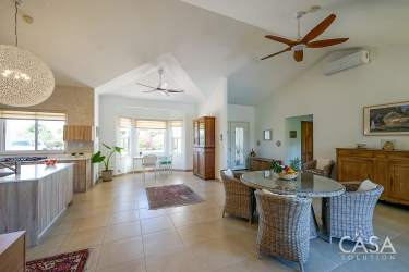 Open kitchen with granite island, light wood cabinets, and modern appliances in Boquete Canyon Village Panama