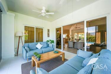 Bright sunroom with blue sofas, sliding doors, and garden scenery in Alto Boquete Panama