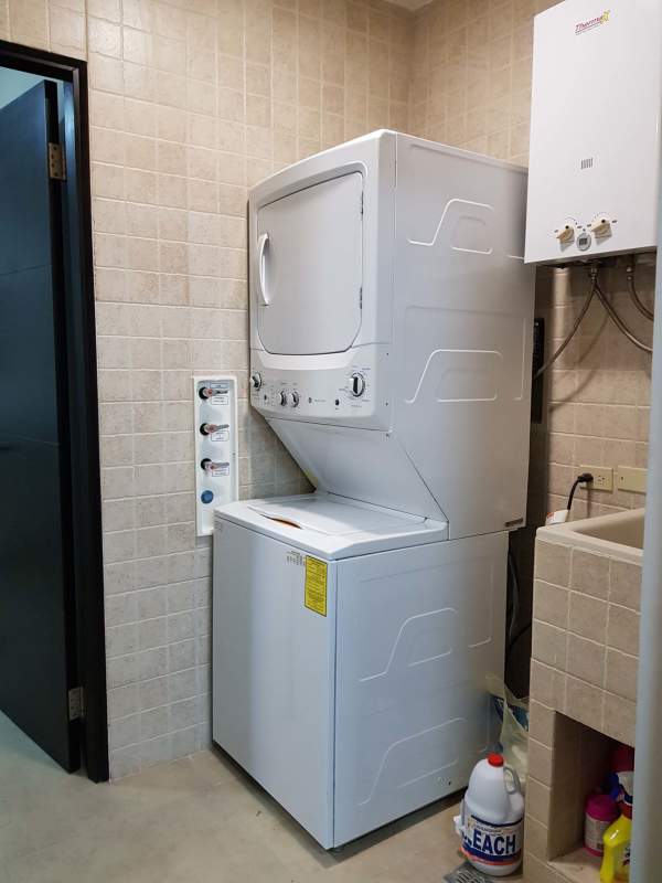 Laundry with stacked washer dryer, utility sink and heater Embassy Village Panama