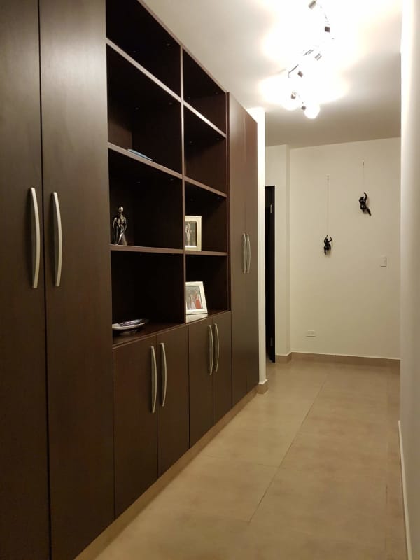Hallway with dark wood cabinets, lighting, wall art and tiles at Embassy Village Clayton Panama