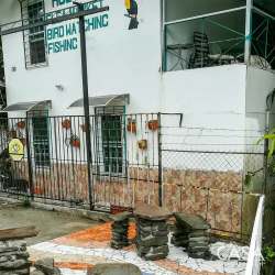 Hostel facade with covered balcony and signage in Cordillera near Macho de Monte
