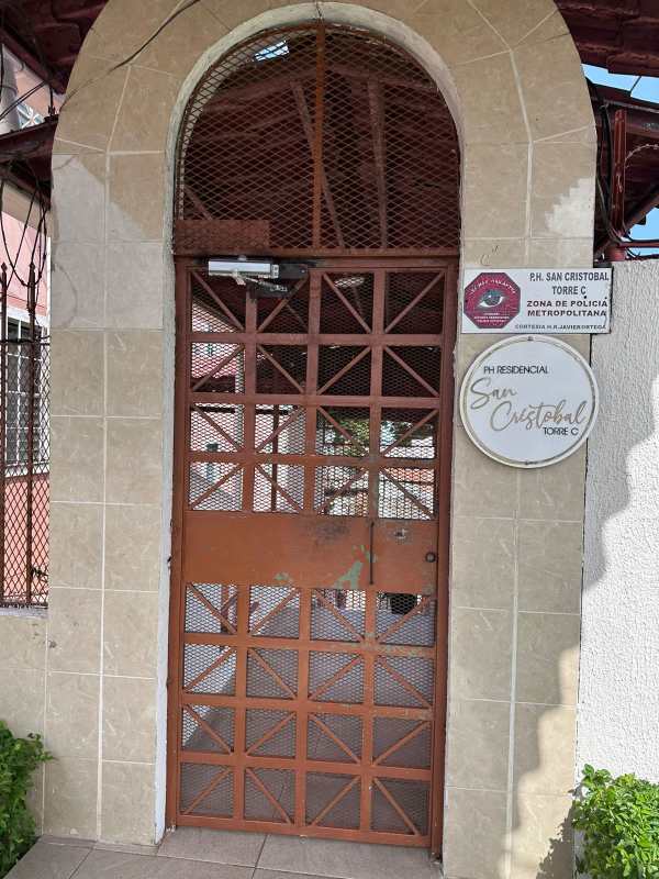 Secured main entrance with metal gate, tiled arch, and signage Residencial San Cristobal