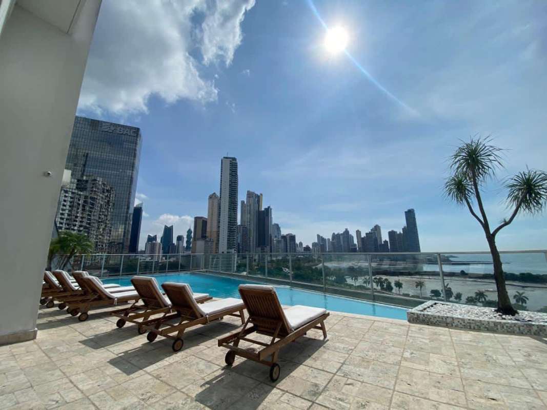 Private balcony with glass railing overlooking ocean and city at PH White Avenida Balboa