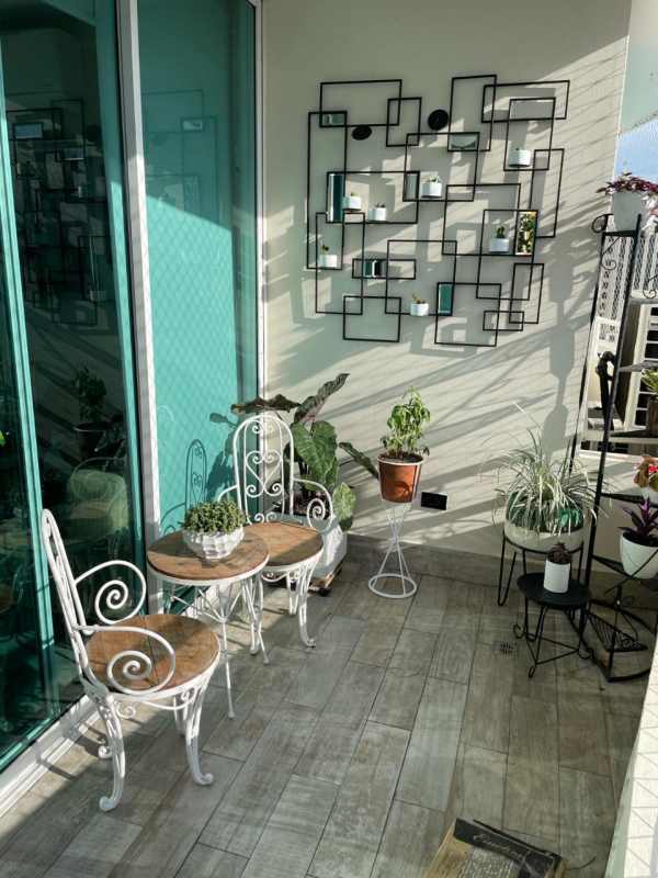 Apartment balcony with metal art, plants, outdoor seating in Coco del Mar Tower