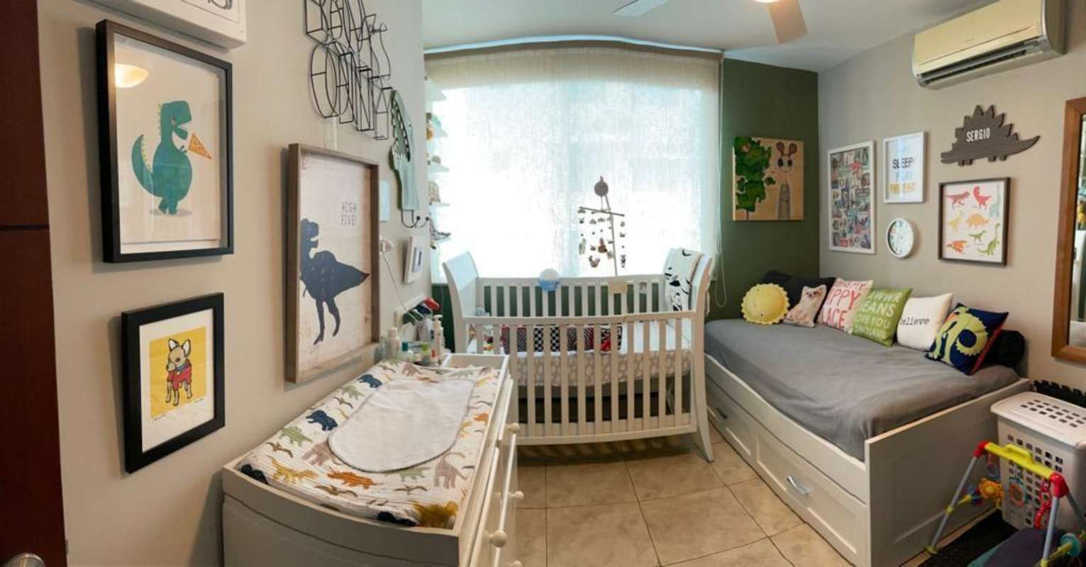 Nursery with crib, twin bed, wall art and toys in PH Coco del Mar Tower Panama