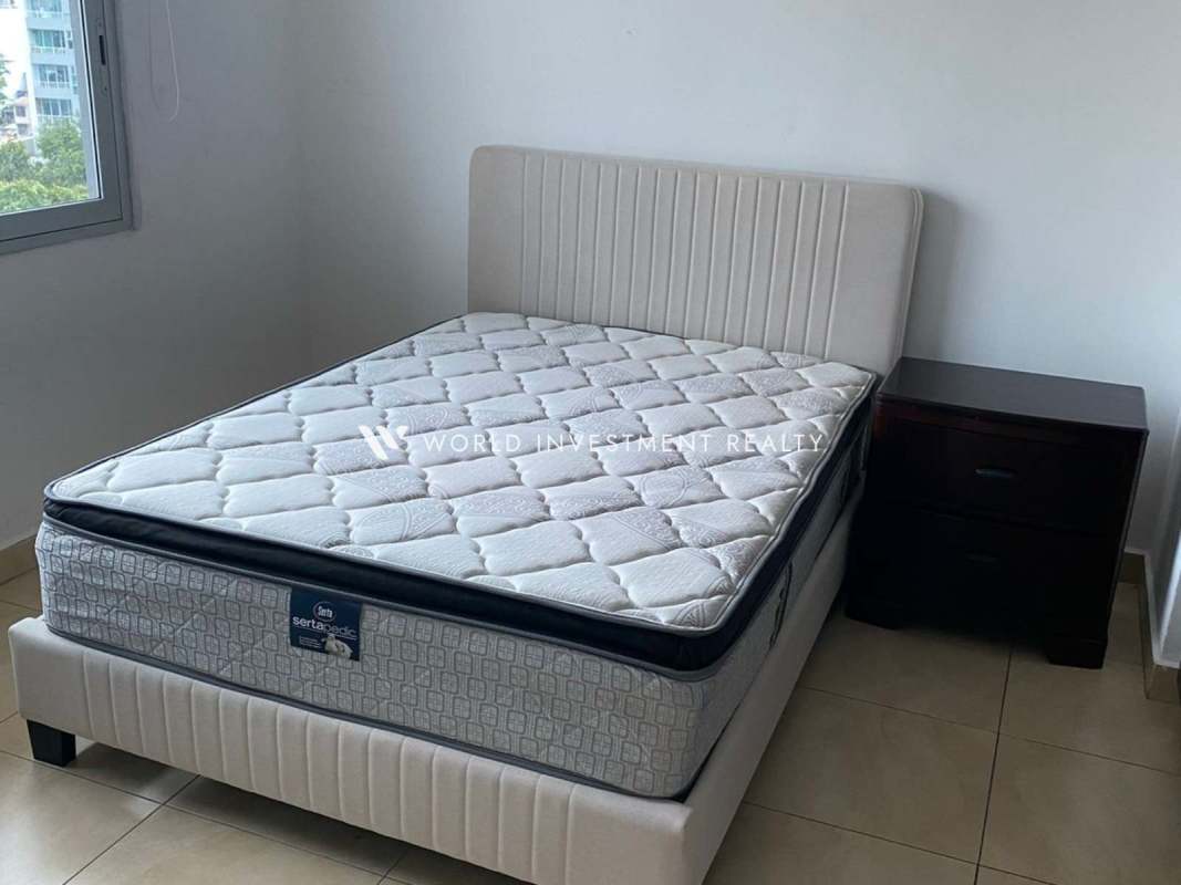 Simple bedroom with upholstered bed and large window PH Park City El Cangrejo