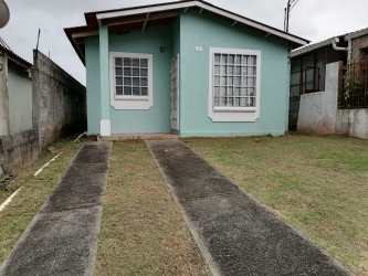 Single-story light blue house with driveway and small yard in Hacienda Los Molinos Costa Verde