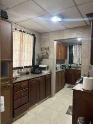 Open plan living dining with large windows and green accent wall in corner house Villa Las Palmeras Arraiján Panama