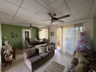 Light-filled living and dining space with ceiling fans in corner house Villa Las Palmeras