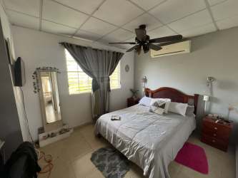 Bedroom or study space with desk built-in bookshelf ceiling fan in Villa Las Palmeras Arraiján Panama