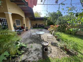 Covered terrace and lush backyard garden in corner house Villa Las Palmeras Arraiján Panama
