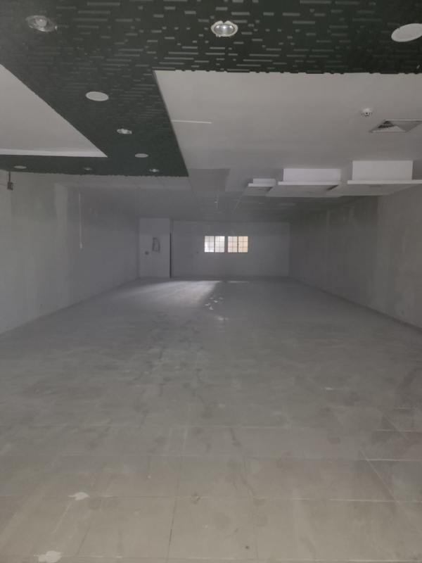 Interior of commercial rental unit with tiled floor, ceiling panels, and unfinished walls in Plaza del Parque Panama City