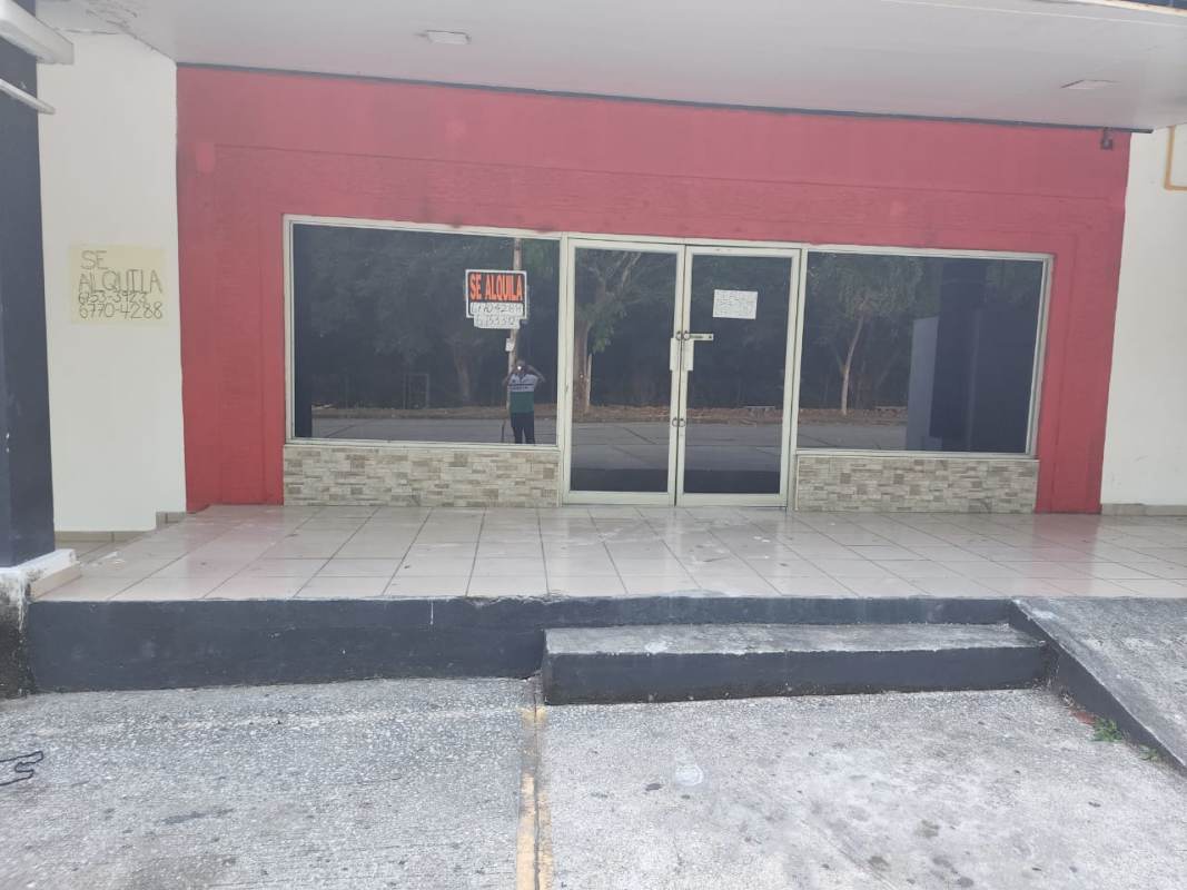 Retail exterior with large glass storefront windows, red facade and double glass doors at Plaza del Parque Panama City