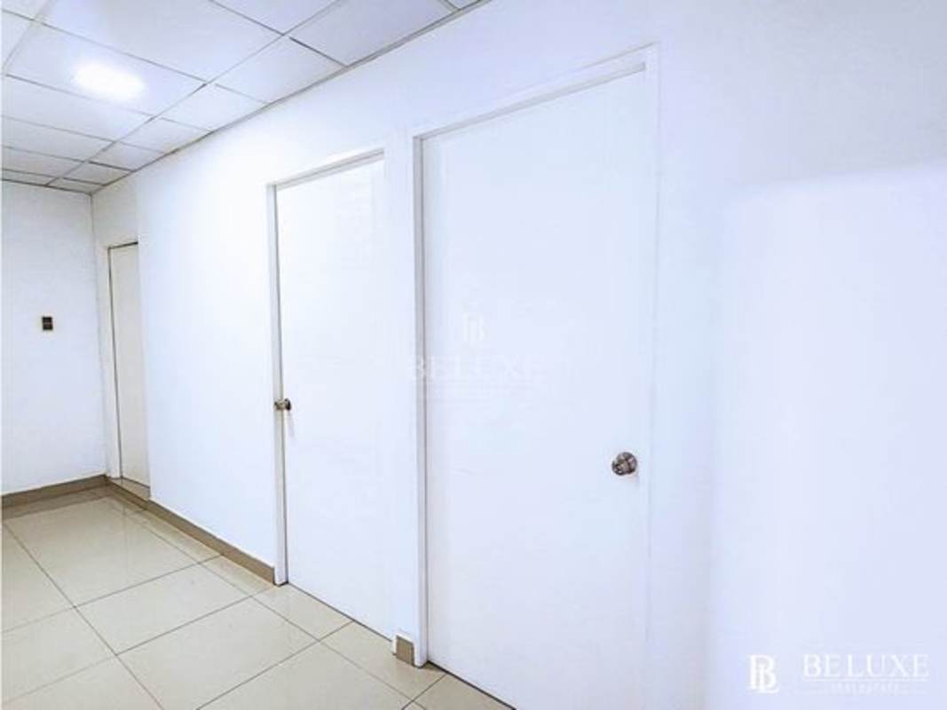 Minimalist hallway with beige floor tiles, white walls, recessed lighting inside PH Plaza Obarrio commercial building Panama